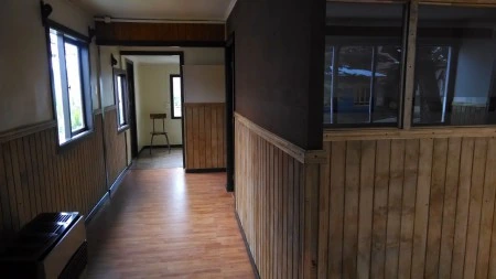 Fotografía original del interior publicado por la empresa, con revestimientos de madera y piso laminado